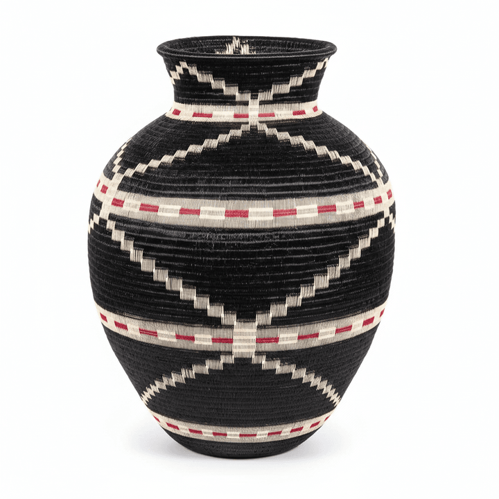 Side view of handwoven Colombian basket showing circular geometric pattern in natural palm fiber dyes