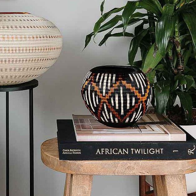 Handwoven Colombian Wounaan basket with indigo-black fibers and copper diamond motif
