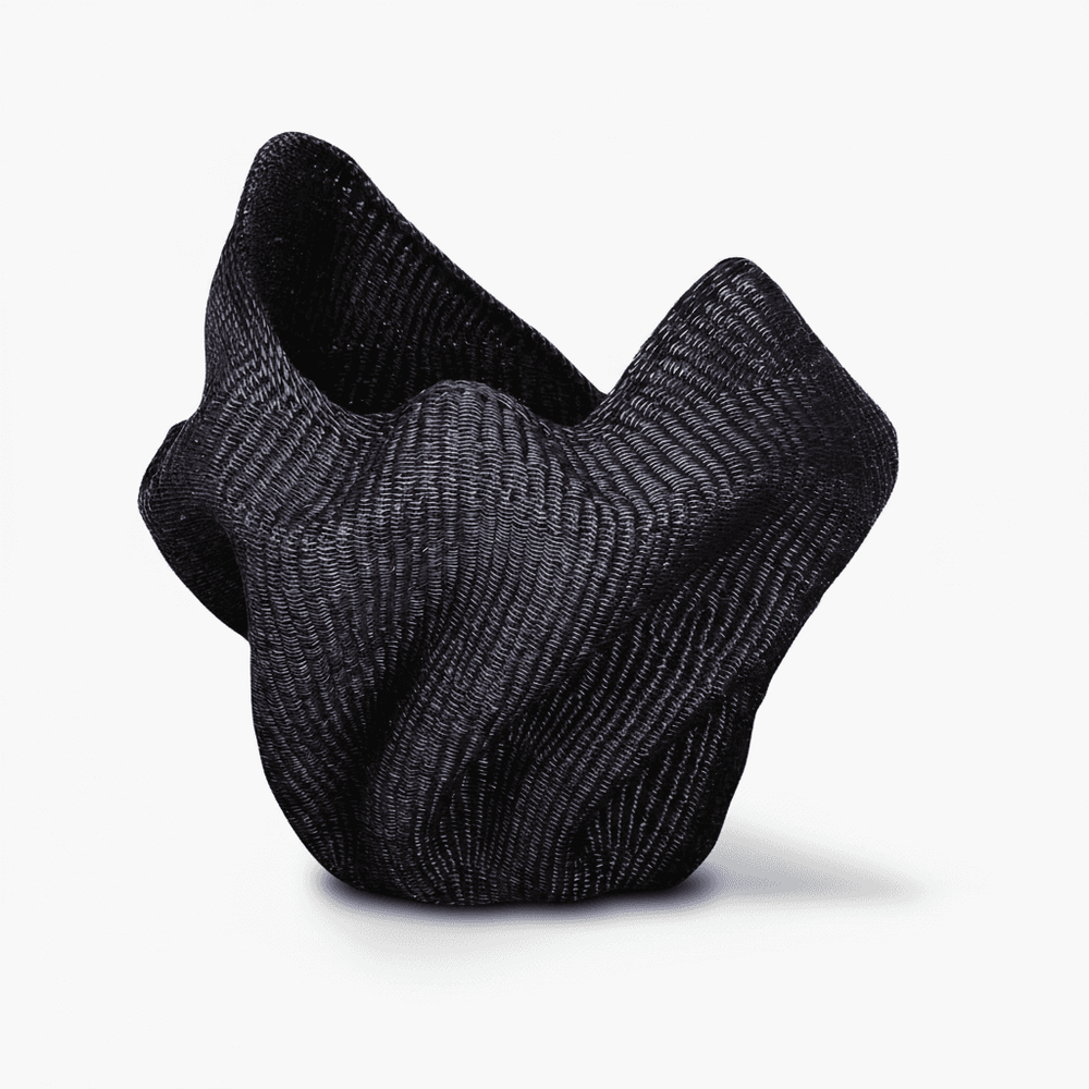 Side angle showing curved wave silhouette and dimensional form of woven basket