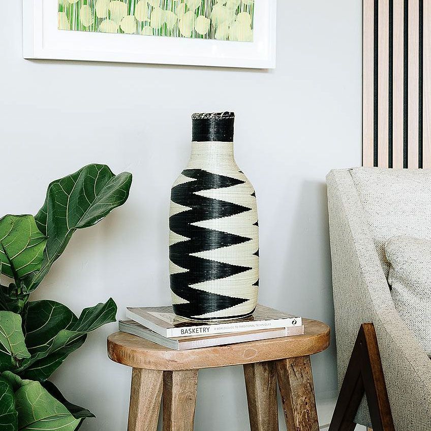 Tall handwoven Rwandan basket with bold zigzag pattern in natural fibers