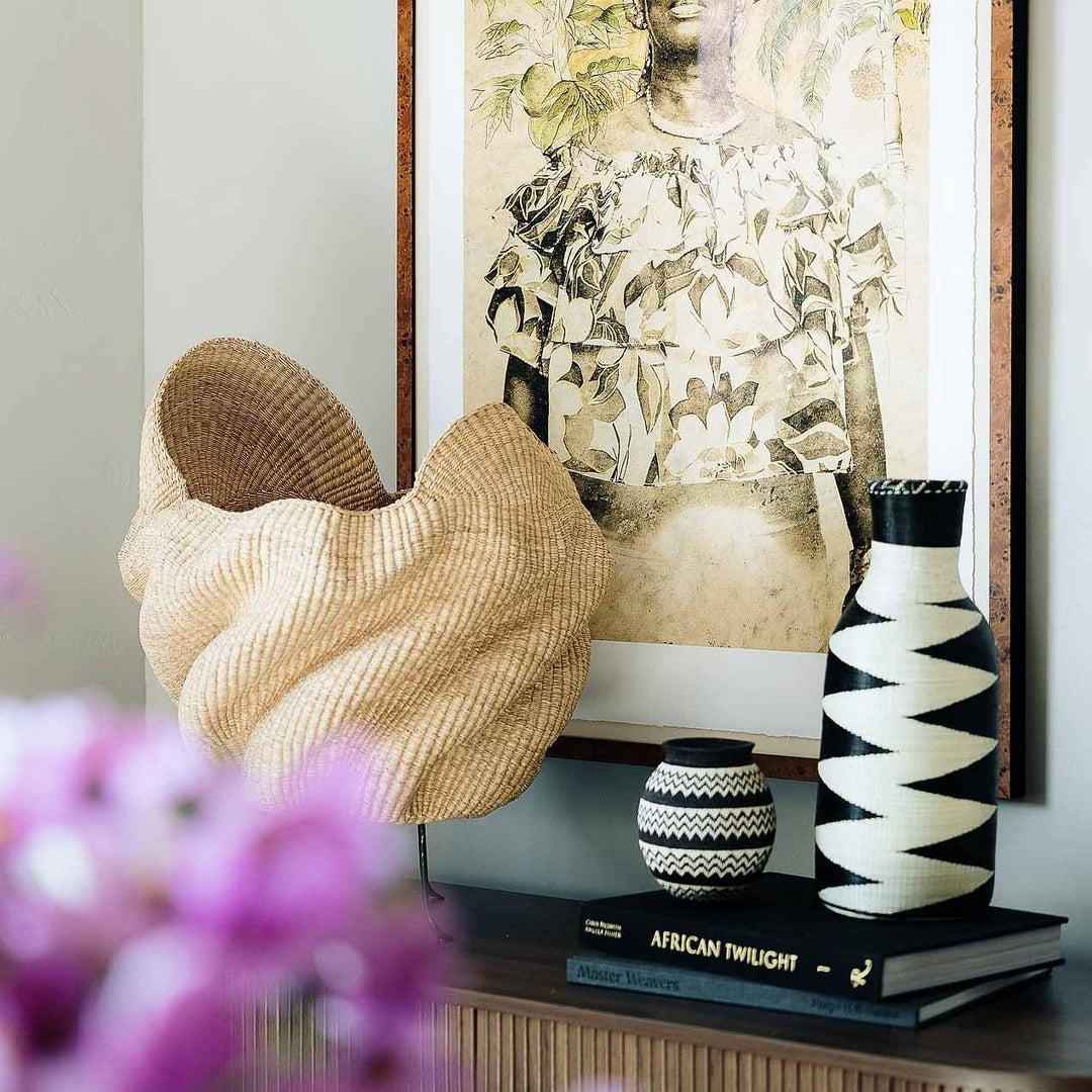 Rwandan woven basket displayed as sculptural decor on modern console table