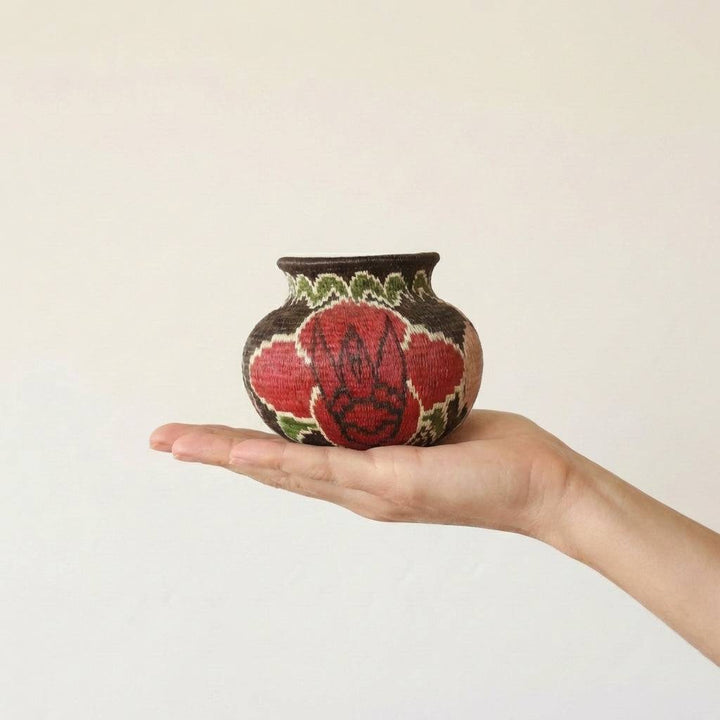 mini decorative basket with floral pattern on black background by Wounaan artisans from Panama