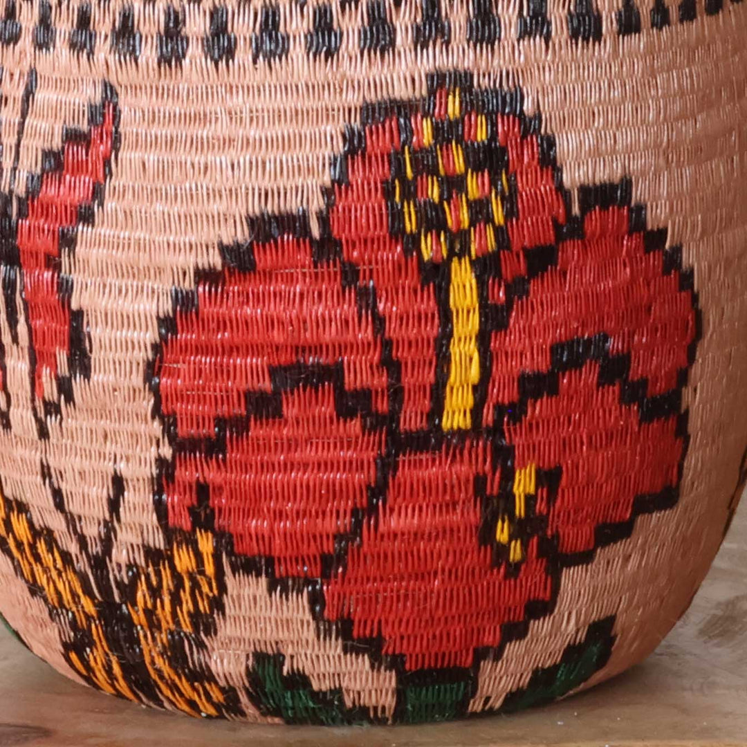 Close-up werregue palm fiber weave showing floral motifs in natural dyes on decorative bowl basket