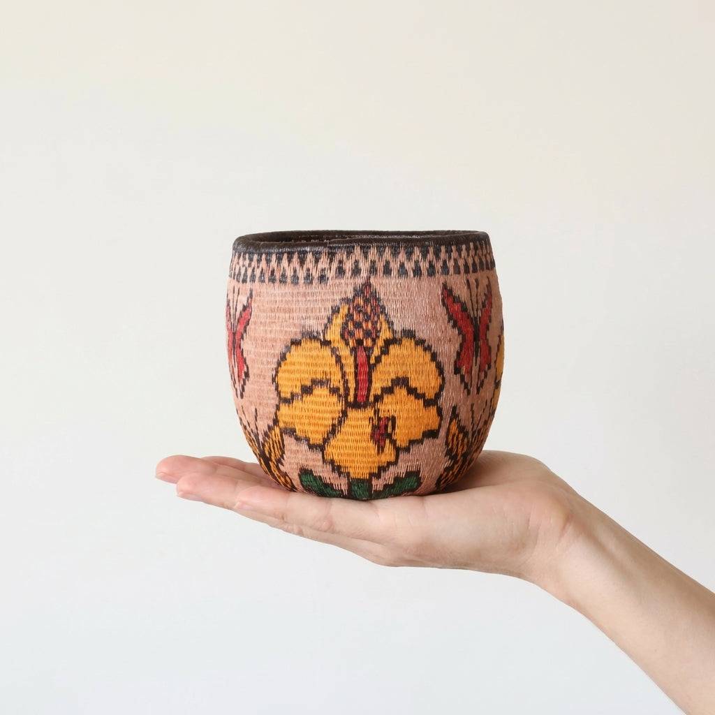 Side view of woven bowl basket showing curved walls and botanical flight design by Wounaan artists