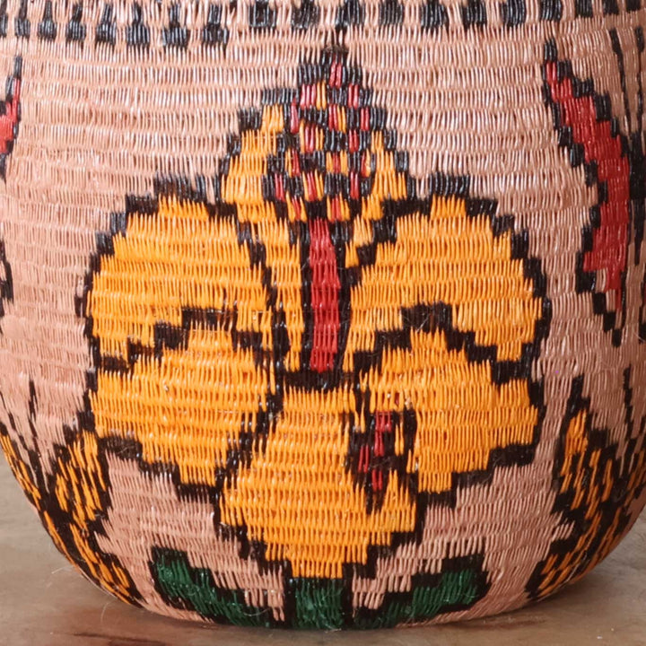 Close-up werregue palm fiber weave showing floral motifs in natural dyes on decorative bowl basket