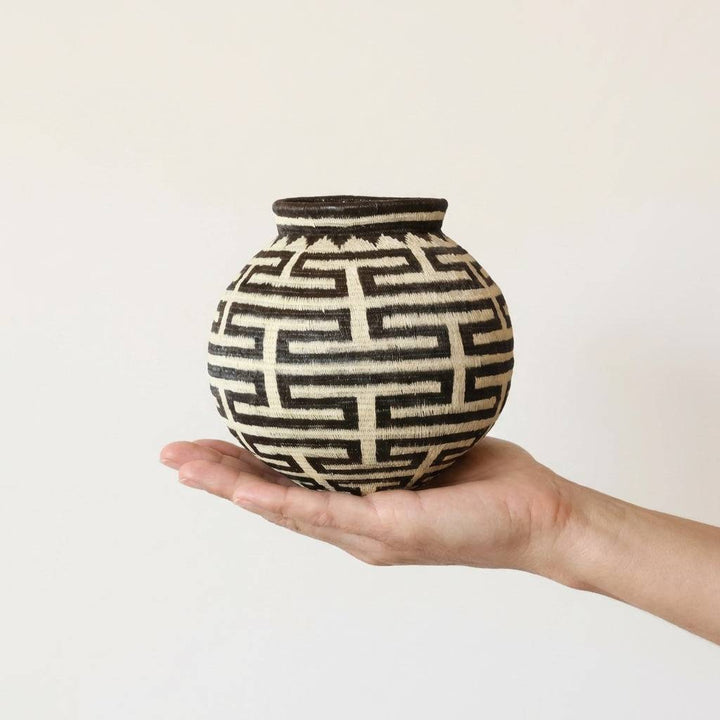 Classic woven basket with intricate labyrinth line patterns handmade by skilled artisans