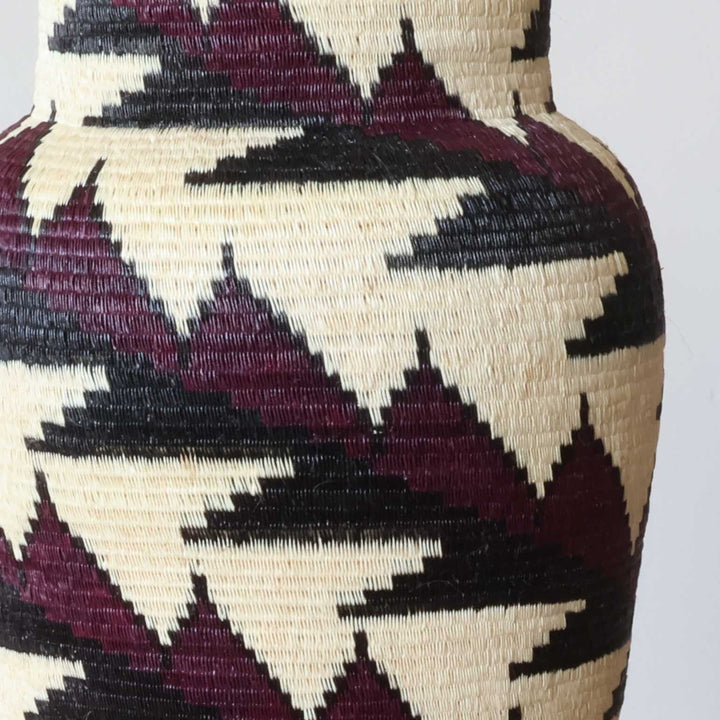 Close-up red black geometric feather pattern weave detail on handmade mini basket