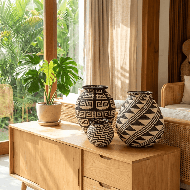 Handmade black feather geometric basket displayed in modern tropical interior decor setting