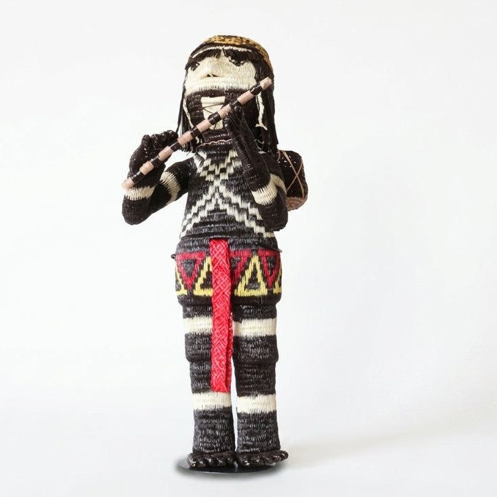 The Flute Player, male Cunana muneca with a woven flute at his mouth