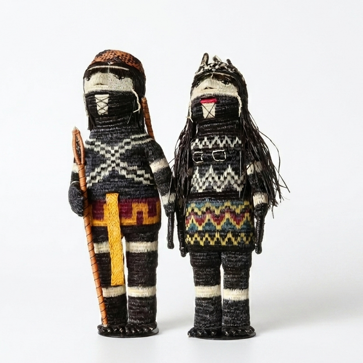 Handwoven Emberá Cunana muñeca pair — “She Who Gathers” shown with its woven companion “The Hunter”, palm-fiber figures from Panama