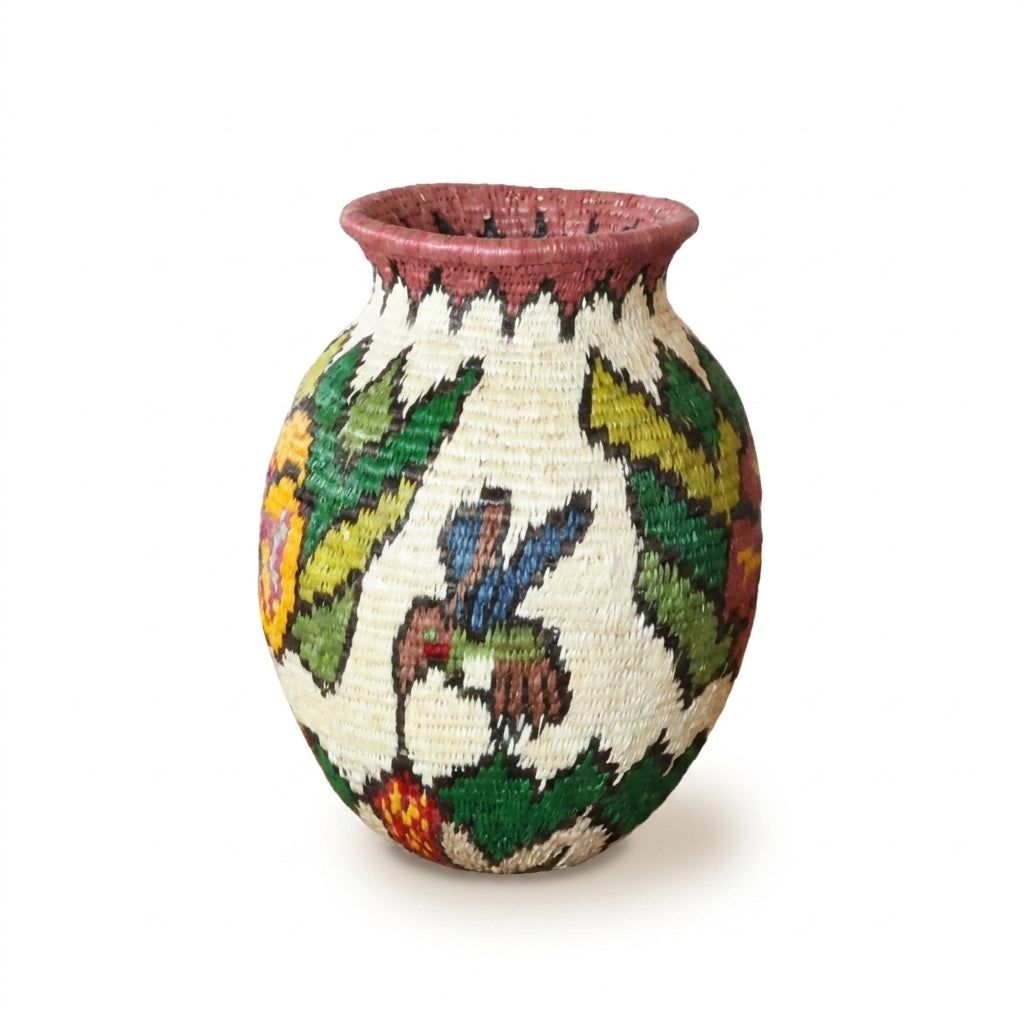 Brown and blue hummingbird in flight among green leaves on cream Wounaan handwoven basket with mauve rim