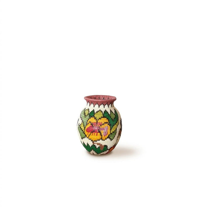 Golden blossom with red-pink center and leaf wreath on mini handwoven Wounaan basket from Panama's Darién