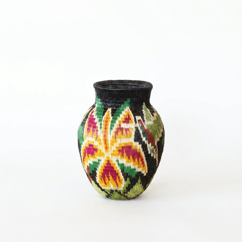 Mini Wounaan handwoven basket with golden and magenta star orchid on black ground, Darién Panama woven art