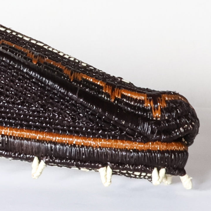 Close-up detail of white zigzag teeth and black-and-cream banding on Emberá crocodile mask