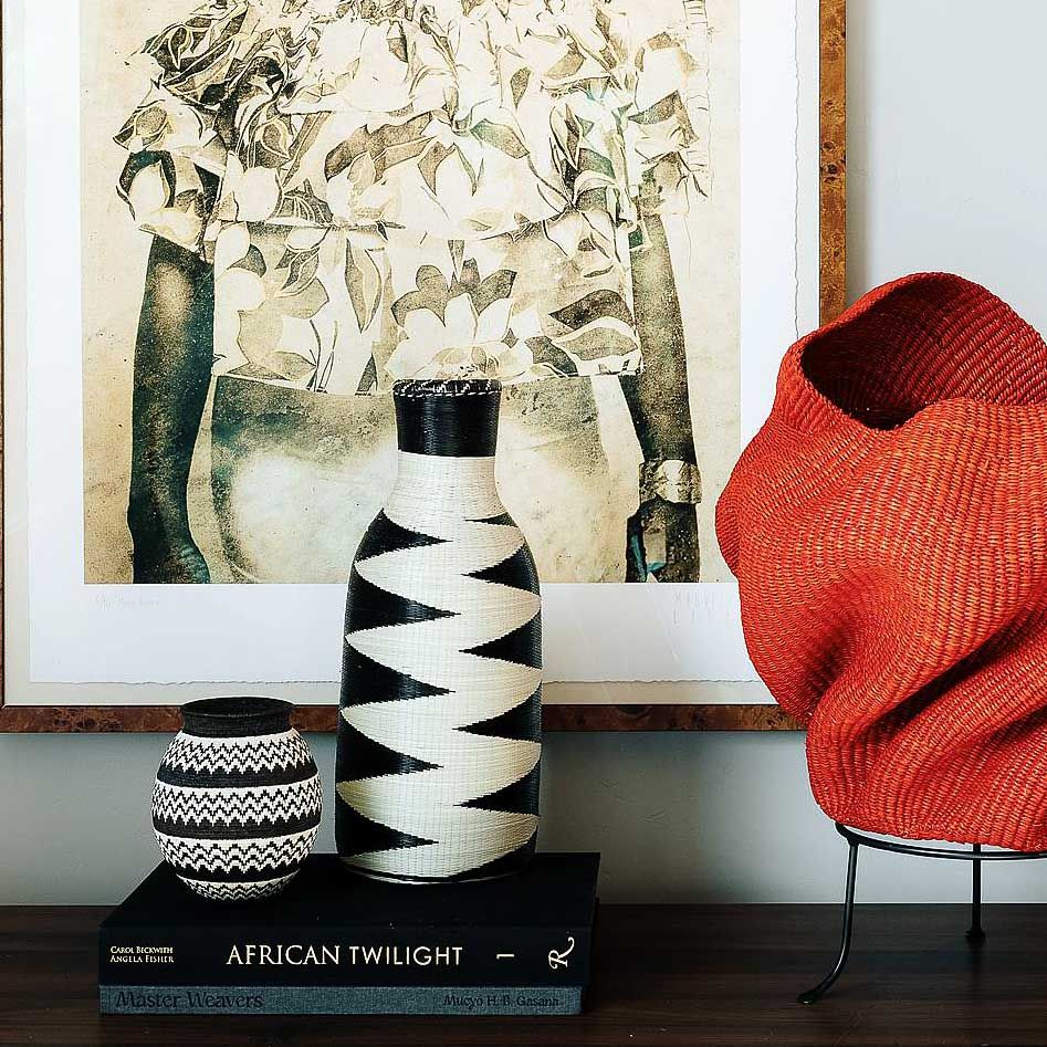 Rwandan woven basket displayed as sculptural decor on modern console table