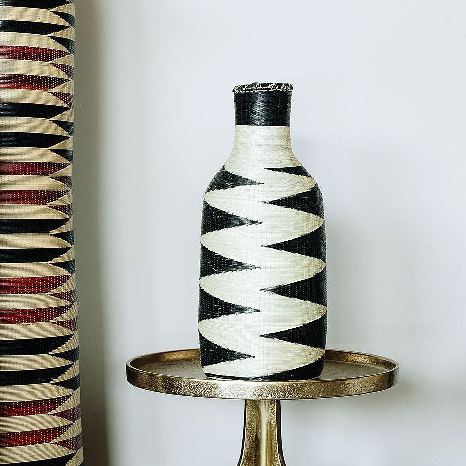 Rwandan woven basket displayed as sculptural decor on modern console table