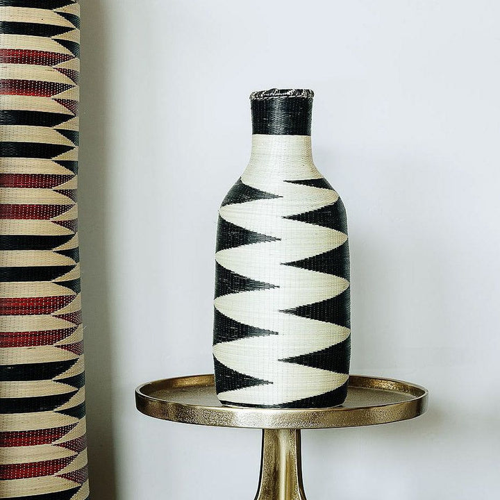 Rwandan woven basket displayed as sculptural decor on modern console table