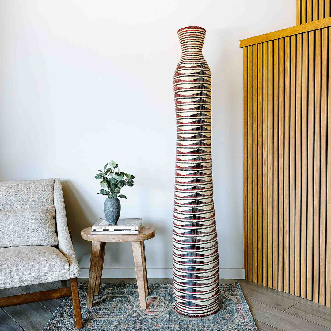 Tall crimson geometric woven column basket handmade by Rwandan artisans from elephant grass