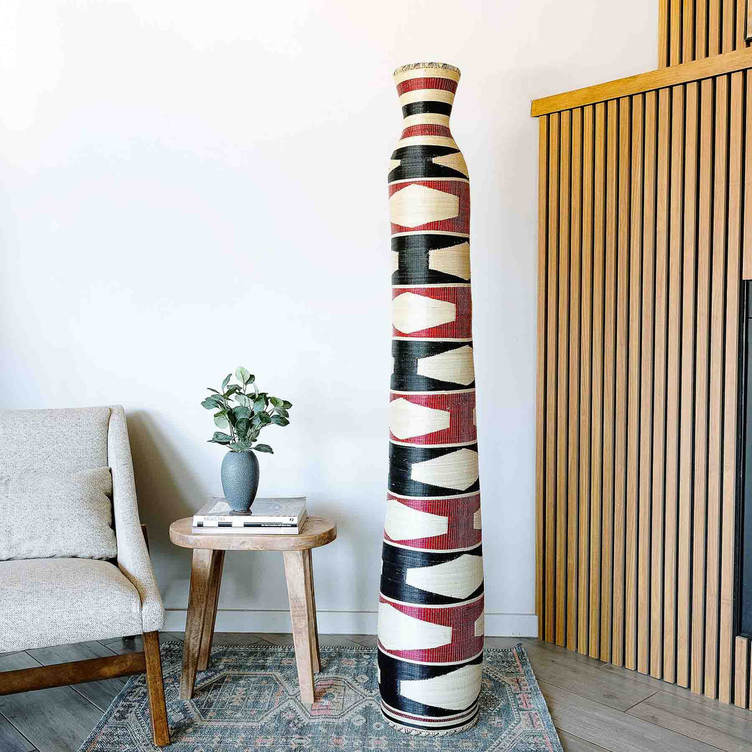 Tall tower woven basket with geometric heritage marks by Rwandan artisans in natural elephant grass