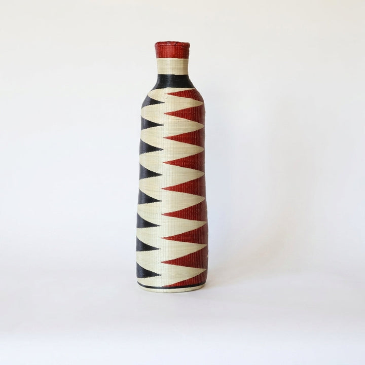 Tall Nyanza bottle basket with red and black sawtooth columns on cream, on white