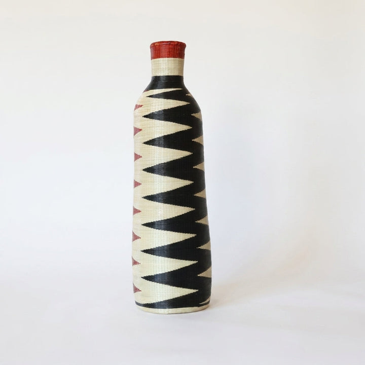 Tall Nyanza bottle basket with red and black sawtooth columns, alternate angle on white