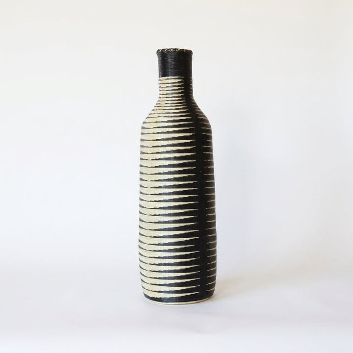 Tall Nyanza bottle basket with fine black and cream ripple stripes, alternate angle on white