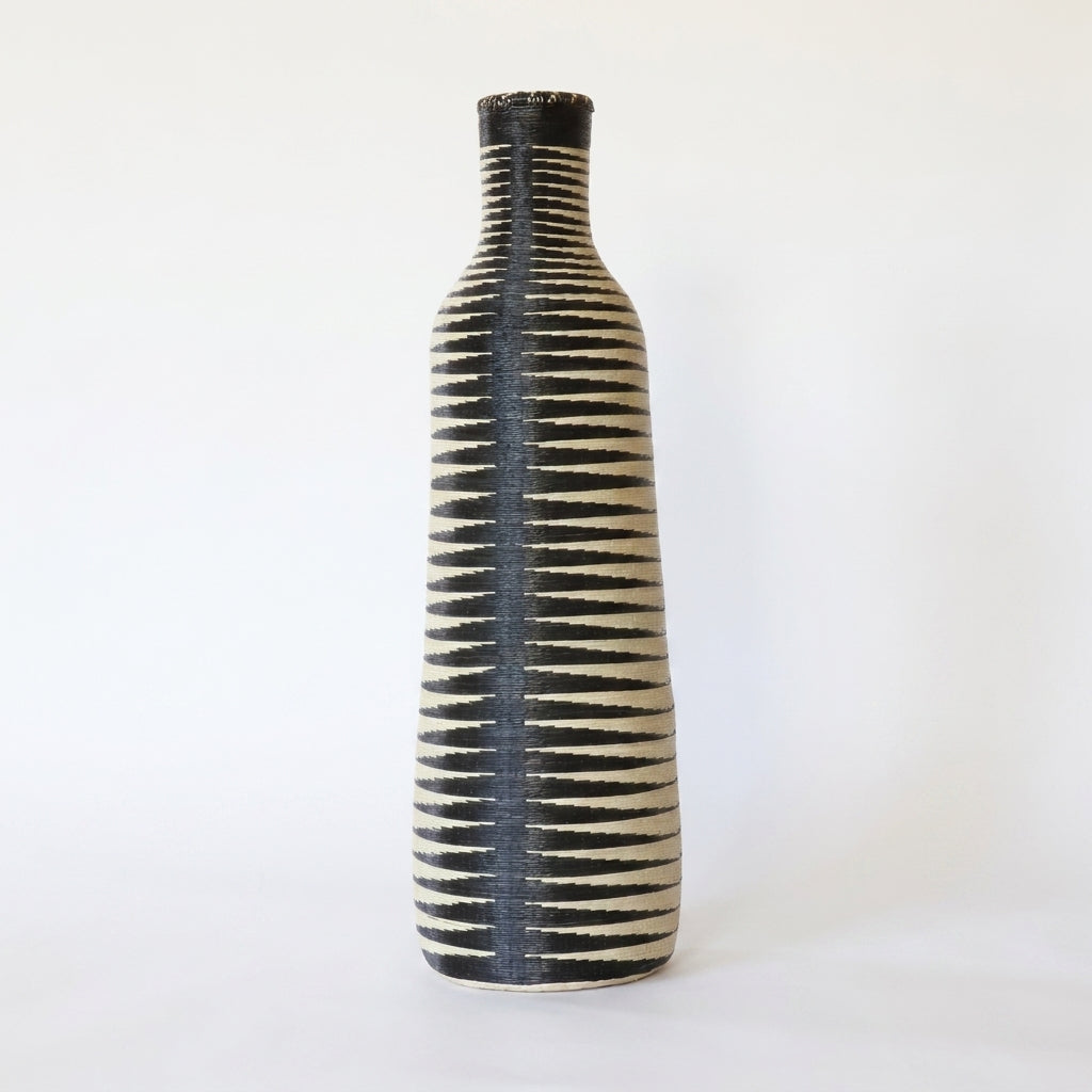Tall Nyanza bottle basket with a dark center spine and black and cream stripes, on white