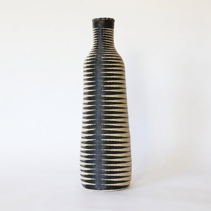 Tall Nyanza bottle basket with a dark center spine and black and cream stripes, on white