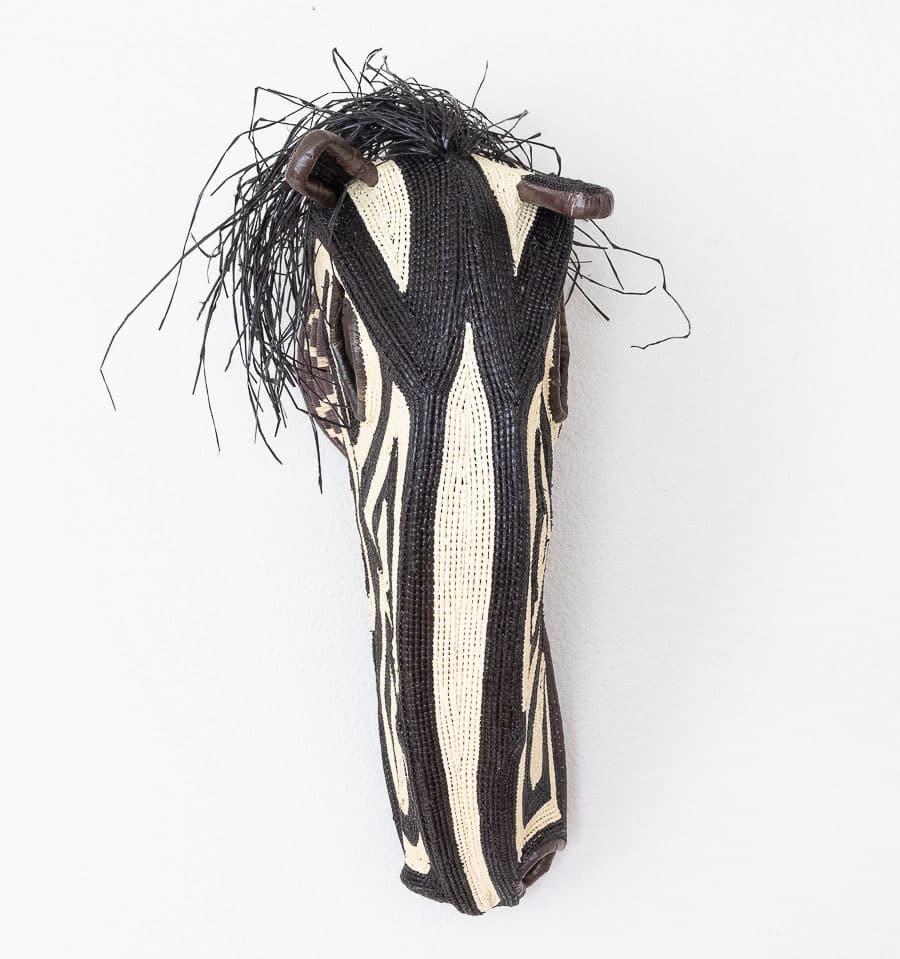 Black and white horse mask handwoven by Embera artisans from Panama's Darién rainforest