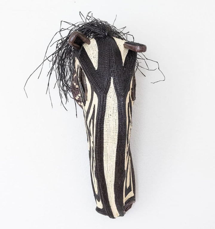 Black and white horse mask handwoven by Embera artisans from Panama's Darién rainforest
