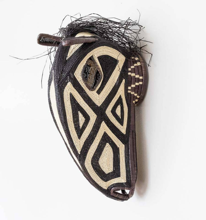 Black and white horse mask handwoven by Embera artisans from Panama's Darién rainforest
