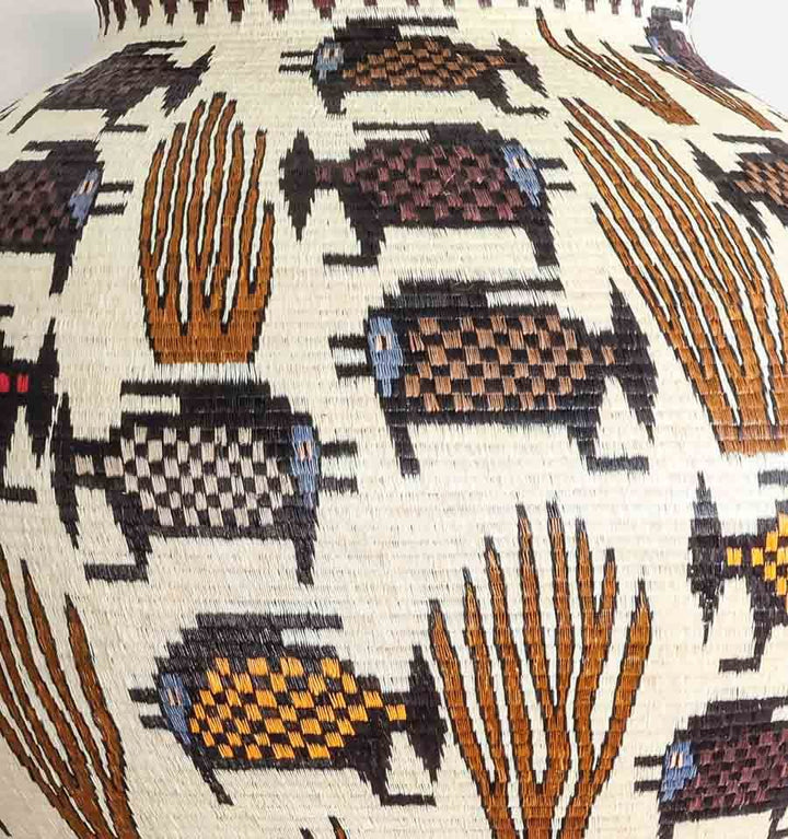 Close-up detail of dotted fish motif and coral geometric weaving pattern in Wounaan palm fiber basket