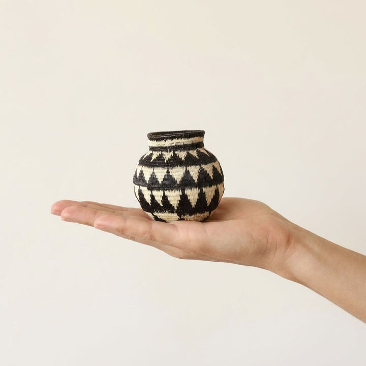 Small ivory woven palm fiber basket with mountain peak geometric patterns by indigenous artisans
