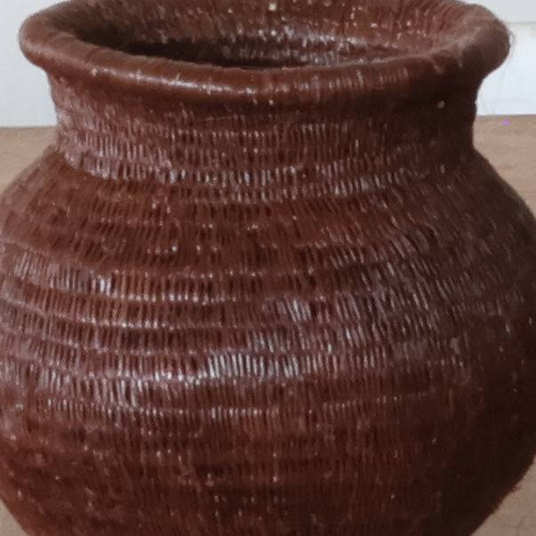 Close-up view showing intricate coiled weave technique and natural brown fiber patterns