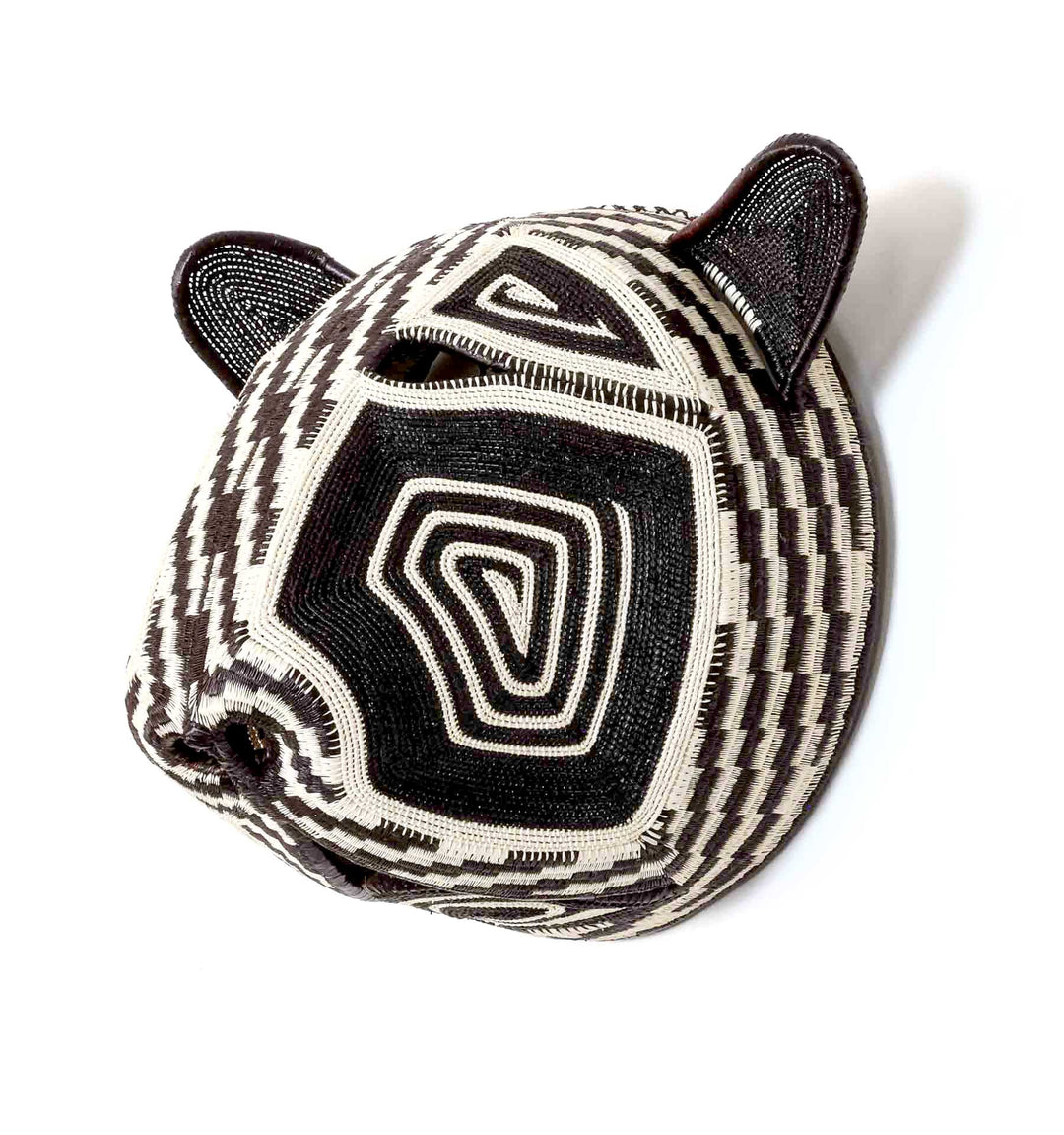Side profile view of handwoven Embera cat mask showing dimensional palm leaf construction and patterns