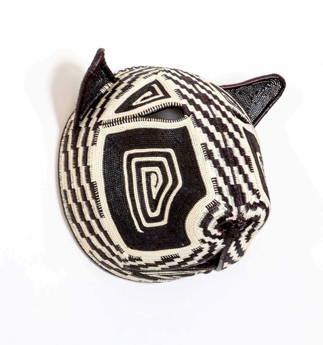 Side profile view of handwoven Embera cat mask showing dimensional palm leaf construction and patterns