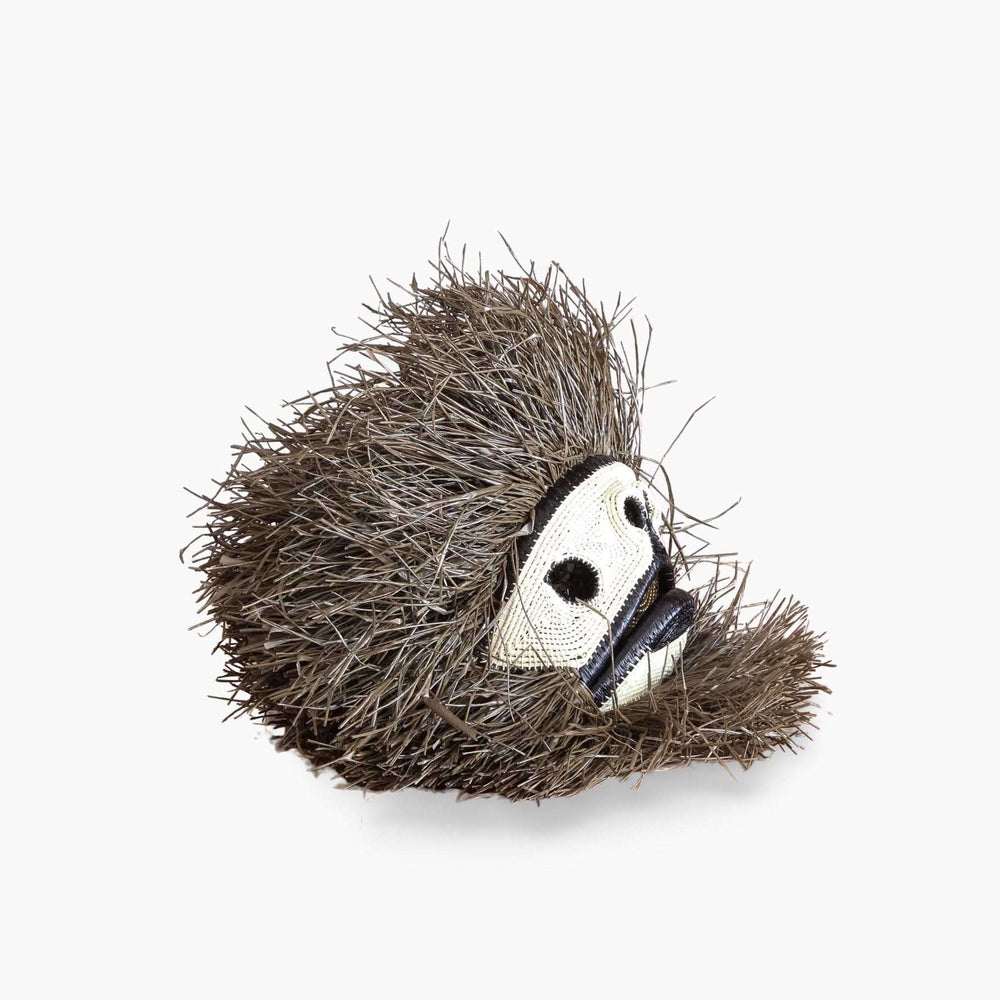 Side profile view showing dimensional palm fiber weaving of handmade monkey mask from Panama
