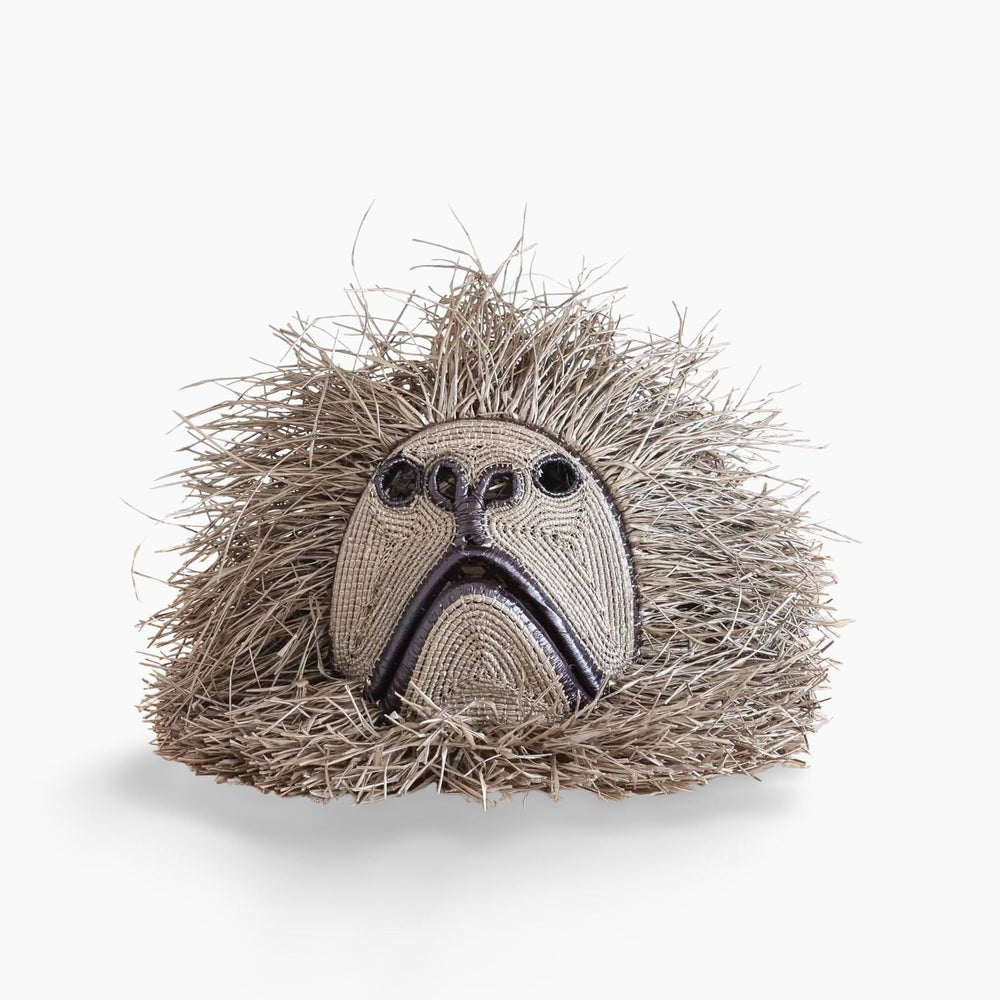 Handwoven Emberá howler monkey mask with bold facial structure and palm fiber fringe from Panama