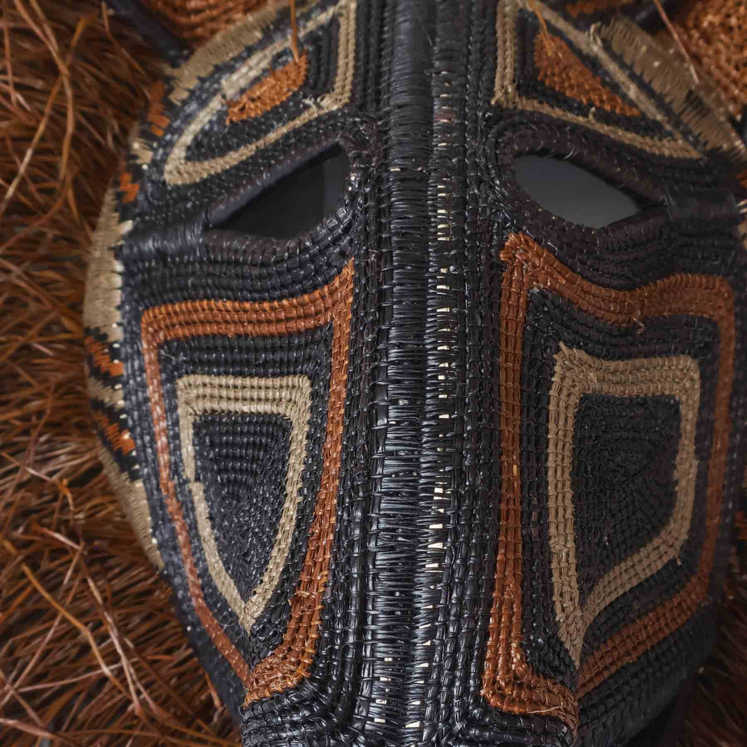 Close-up of chunga palm fiber weaving and natural dye detailing on spirit cat mask