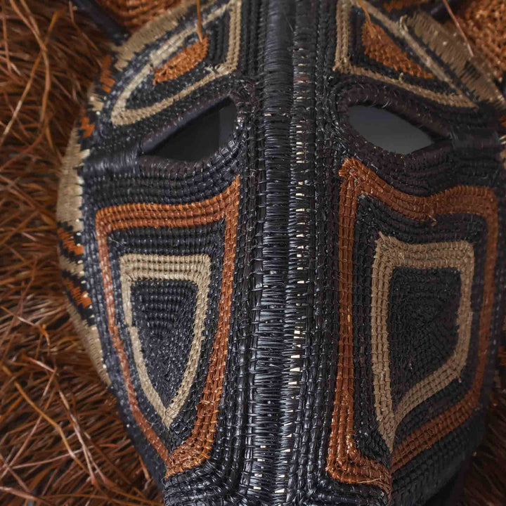 Close-up of chunga palm fiber weaving and natural dye detailing on spirit cat mask