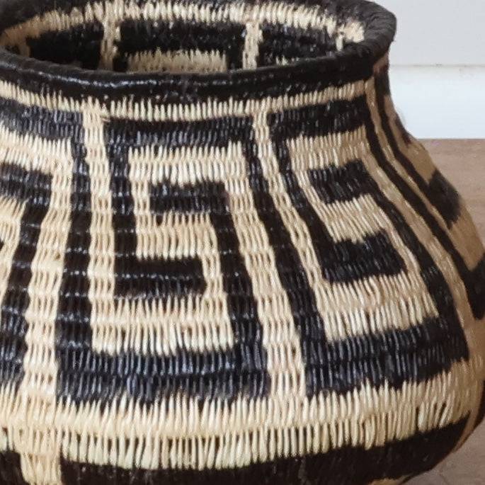 Close-up detail of tight palm fiber weave showing botanical floral pattern craftsmanship