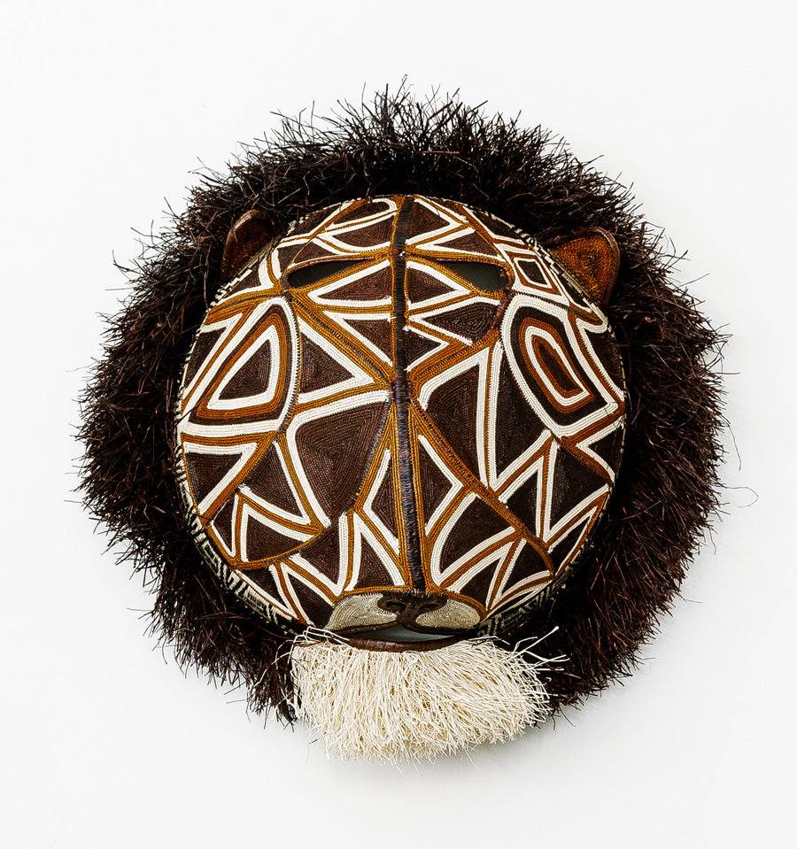 Geometric Cat Mask, woven art by Embera weaver Felicinda Guaynora, Panama palm fiber feline mask with bold white-lined geometric patterns, shaggy mane, and ivory beard.
