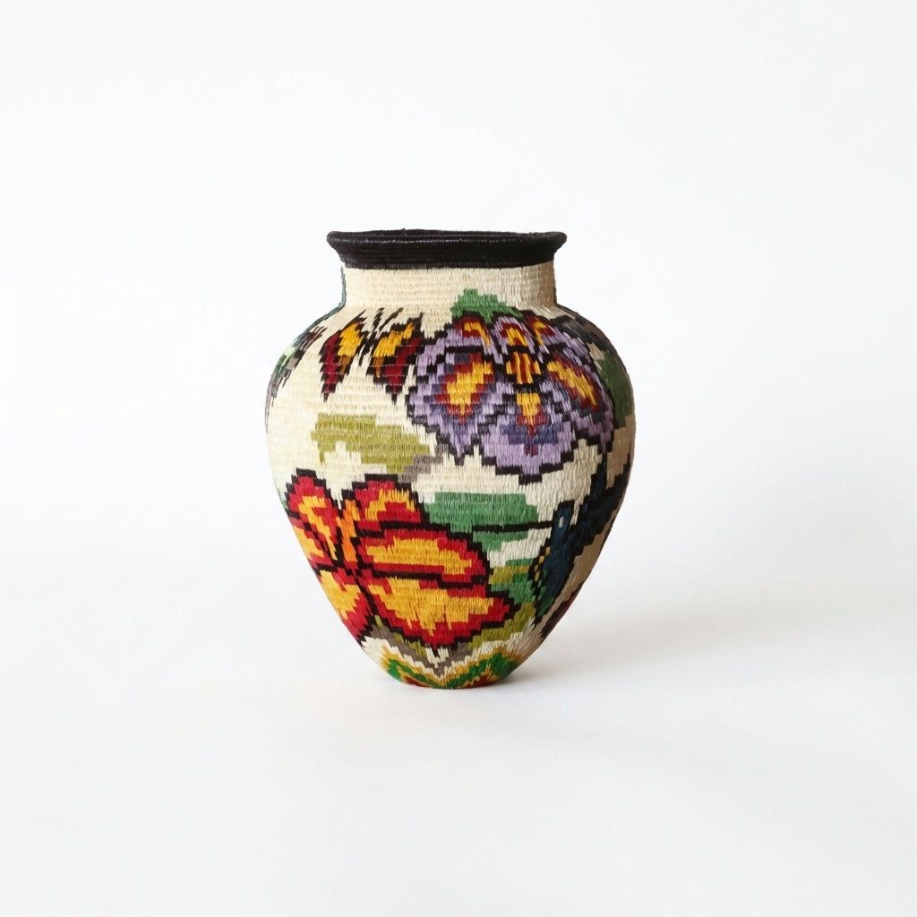 Handwoven Wounaan basket from Panama with purple and red-orange flowers, butterfly and hummingbird on cream ground