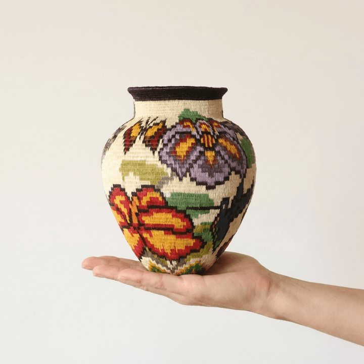Hummingbird garden handwoven Wounaan basket held in hand showing miniature scale, floral motifs on cream