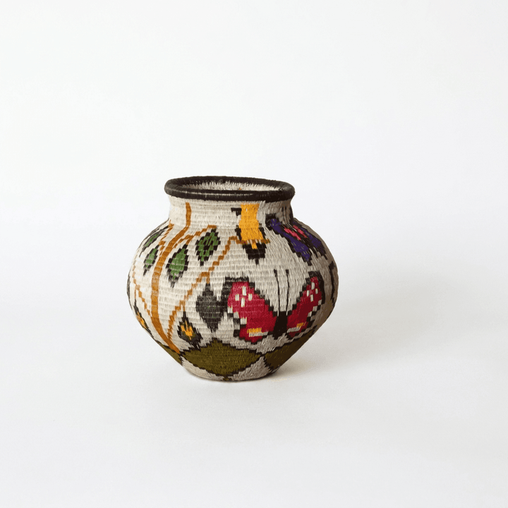 Handwoven Wounaan basket with crimson butterfly, golden blooms and green vines on cream palm fiber
