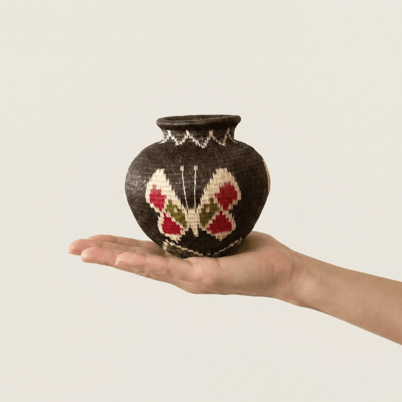 Cacao-brown handwoven Wounaan butterfly basket held in hand showing miniature scale