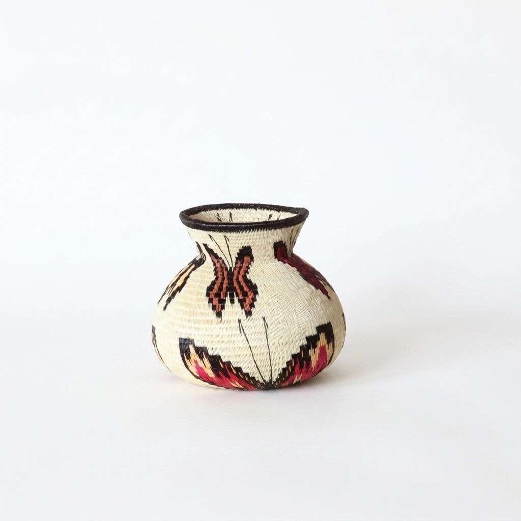Ivory handwoven Wounaan basket from Panama with terracotta, red and gold butterflies and flared dark rim