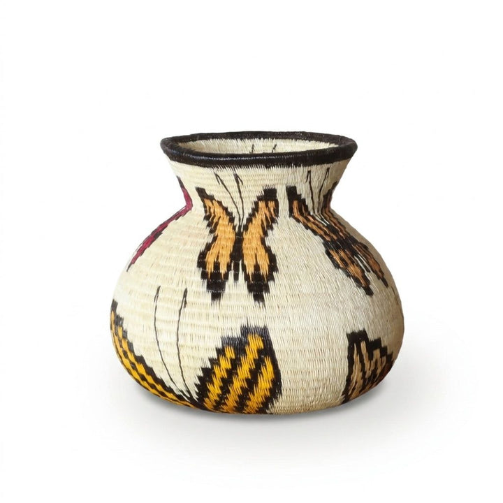 Handwoven Wounaan basket showing amber monarch butterflies and gold-black banded wings on ivory weave