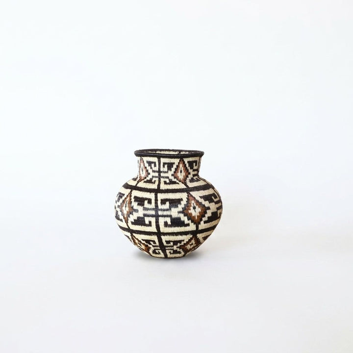 Small geometric handwoven Wounaan basket with stepped maze pattern in brown, ivory and cinnamon