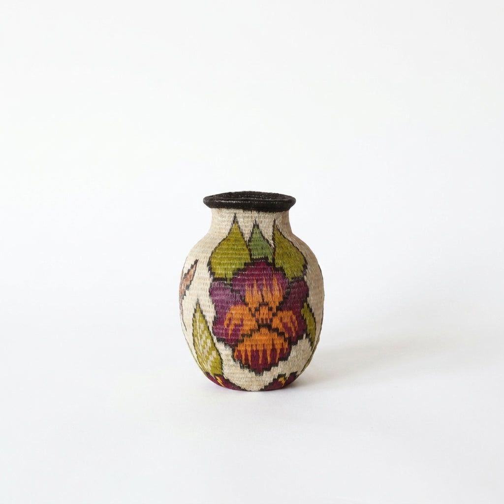 Mini handwoven Wounaan basket from Panama with plum-magenta and orange blossom and olive leaves on cream